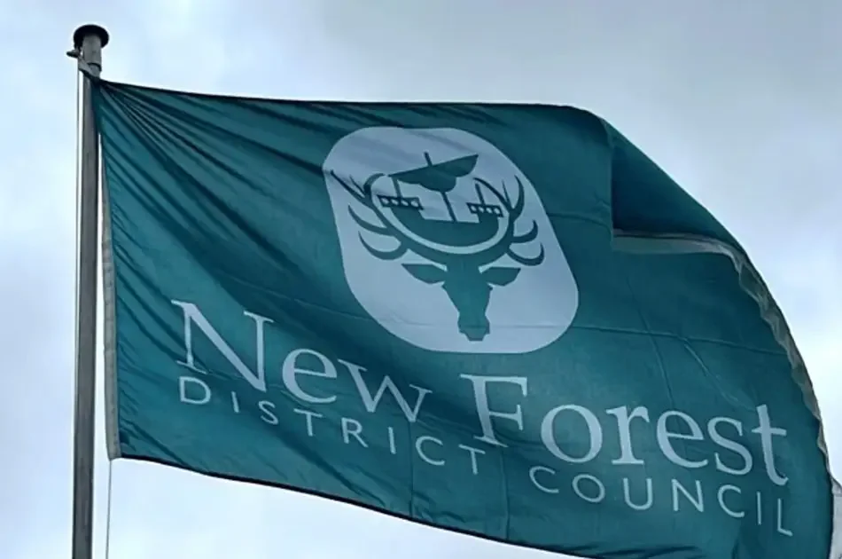 The New Forest District Council flag, featuring a white stag and ship emblem on a green background.